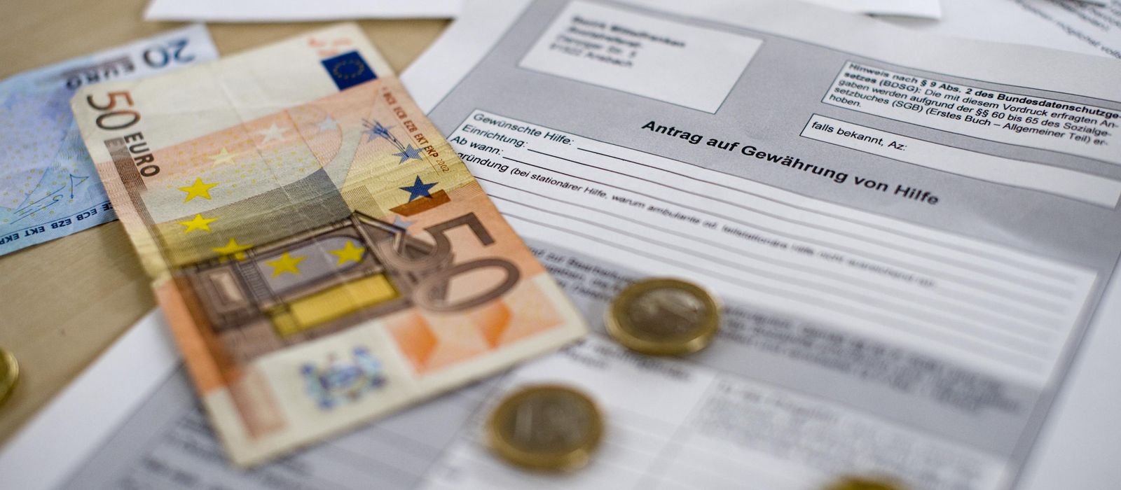 Ein fünfzig Euro Schein und Kleingeld liegen auf einem ausgedrucktem Fomular.