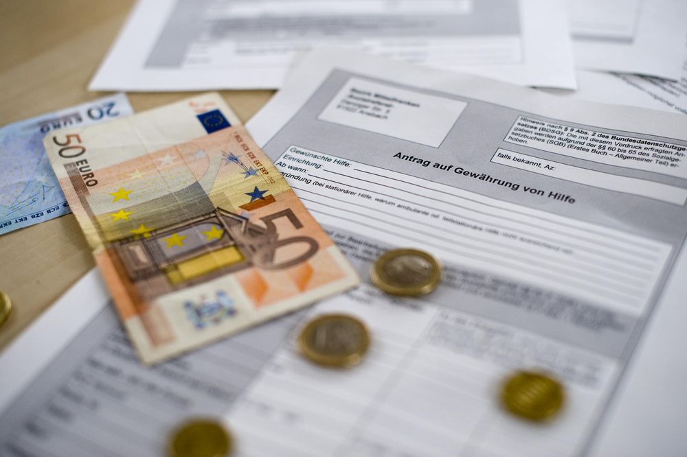 Ein fünfzig Euro Schein und Kleingeld liegen auf einem ausgedrucktem Fomular.