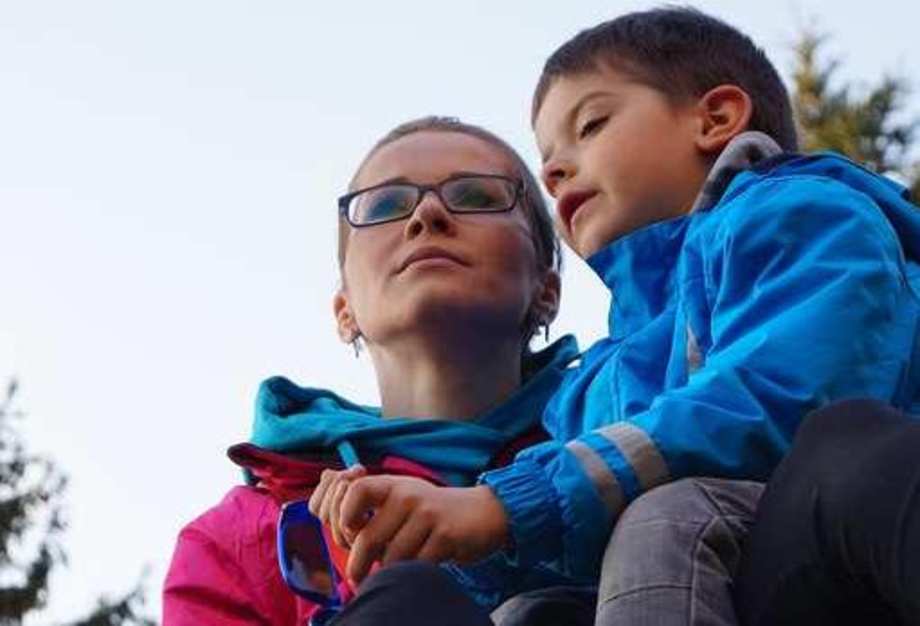 Eine Frau mit Brille steht neben einem etwa fünfjährigen Jungen.